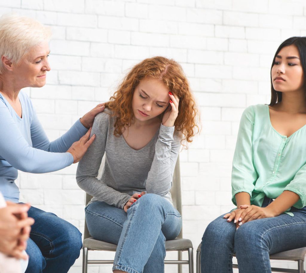 psychologist supporting depressed girl during grou 7BKCVN6